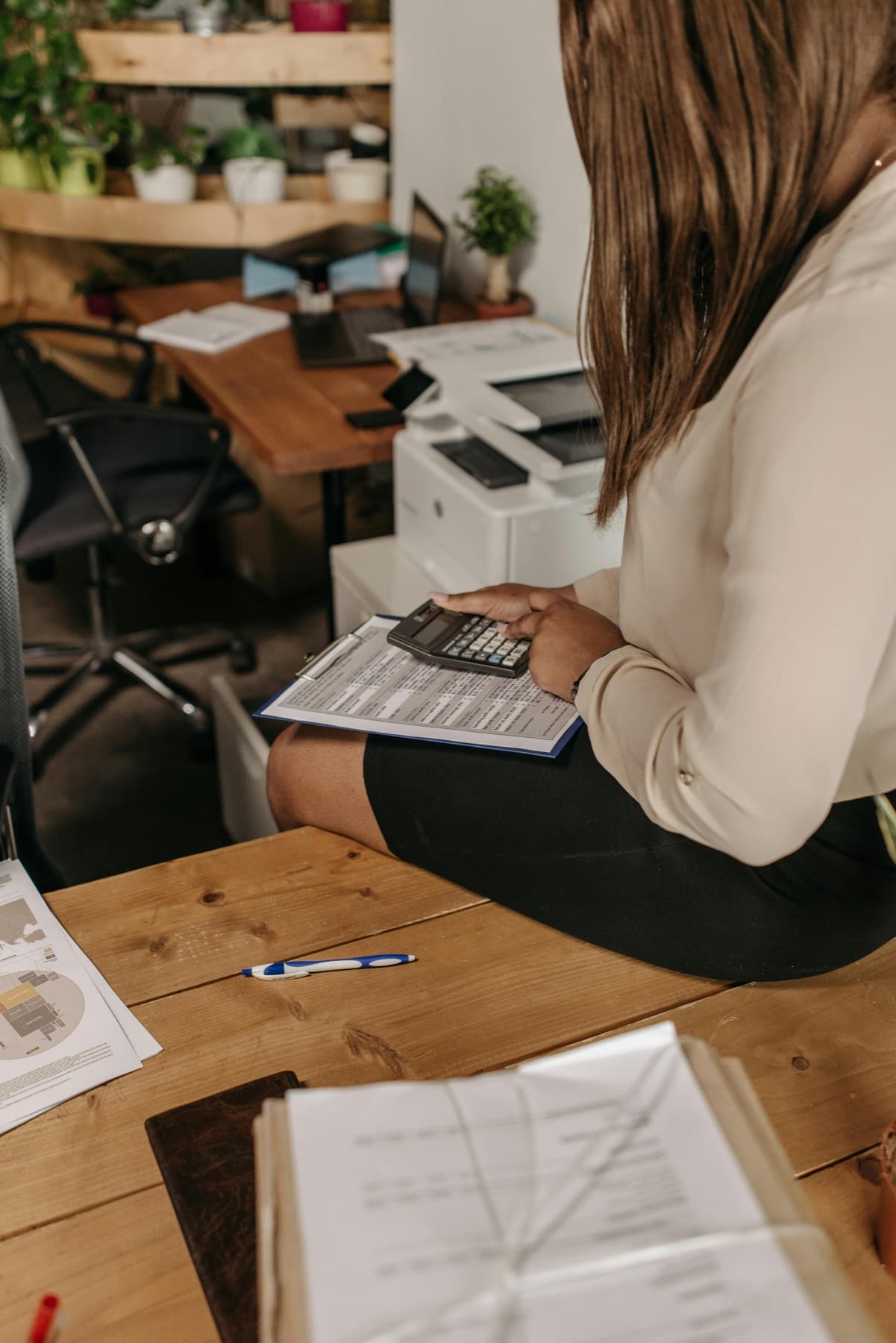 Professionnelle de la comptabilité au bureau avec calculatrice et documents